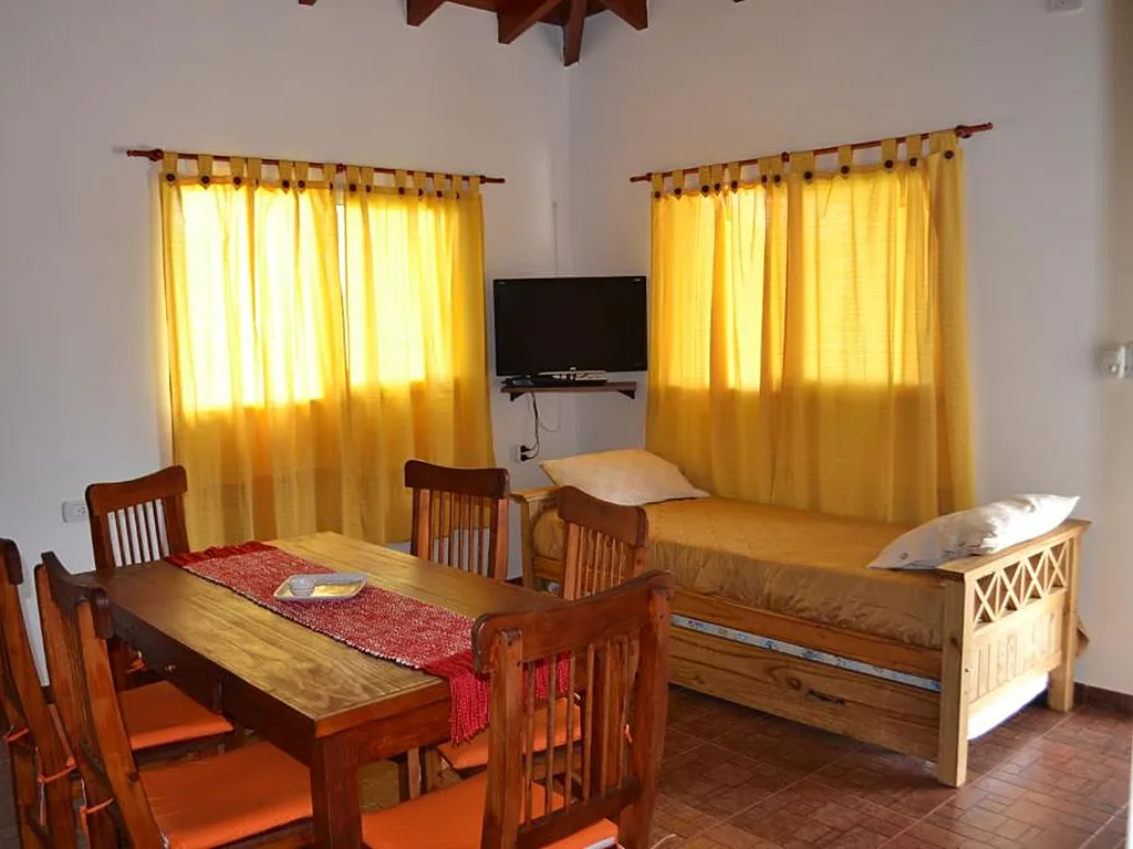 Estar comedor con diván cama y techo de madera, Aguas Mornas, cabañas en Mina Clavero
