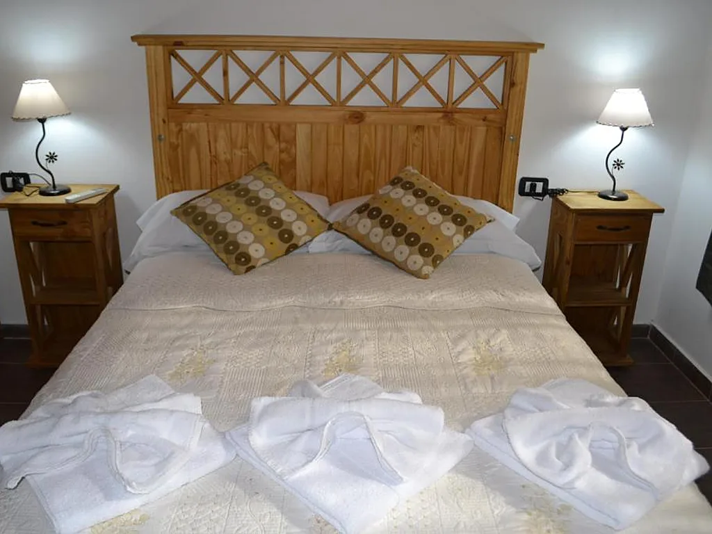 Habitación matrimonial con ropa blanca y toallas, Aguas Mornas, cabañas en Mina Clavero