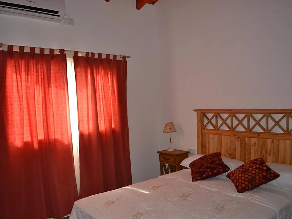 Habitación con aire acondicionado y cortinas rojas, Aguas Mornas, cabañas en Mina Clavero