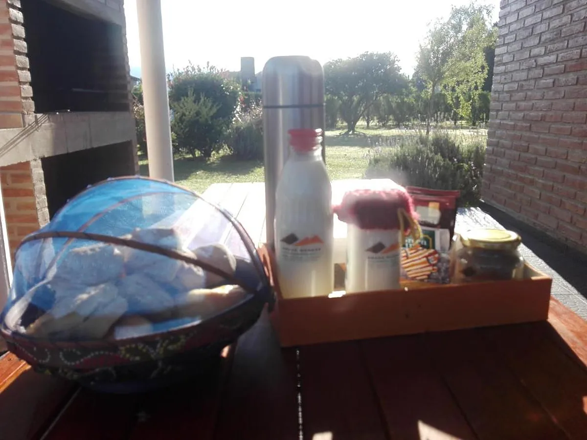 Desayuno en la galería de la cabaña, con la parrilla de ladrillo